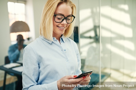 Portrait of blonde businesswoman smiling and checking her cell phone by Flamingo Images from NounProject.com