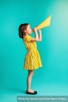 girl in yellow dress with yellow cone held up to her mouth